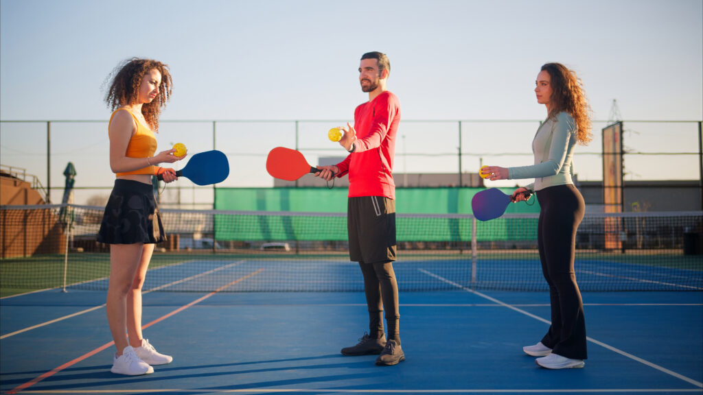 San Antonio pickleball player gripping a sore elbow between points