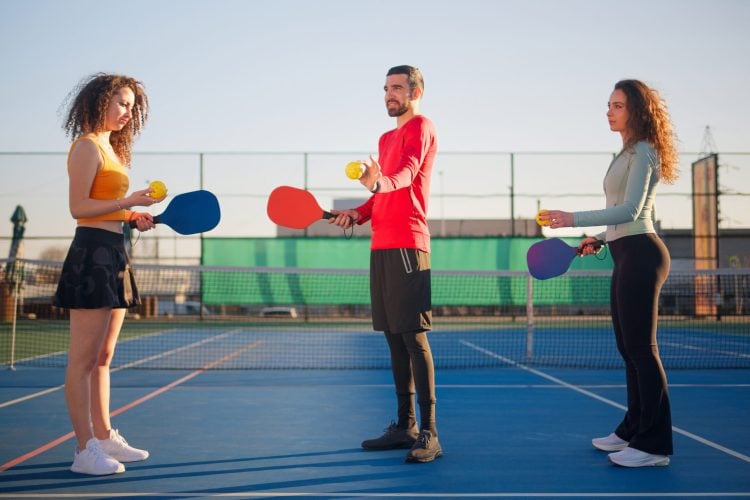 San Antonio pickleball player gripping a sore elbow between points